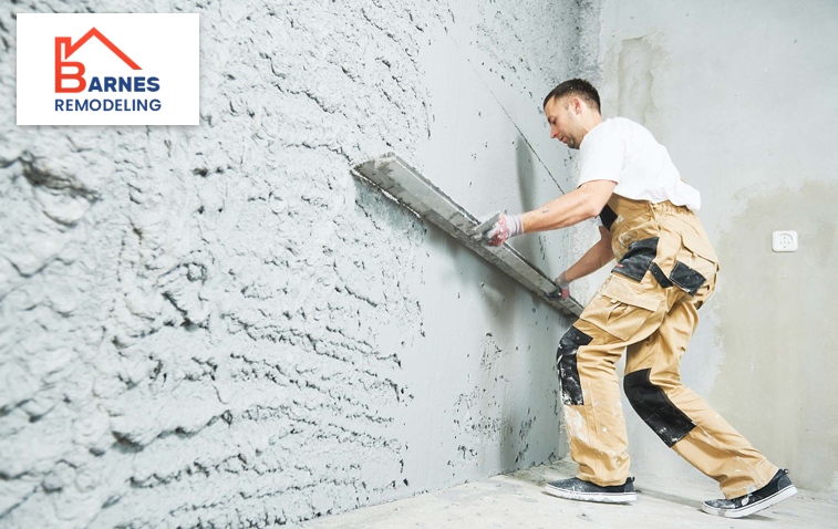 Worker applying plaster to a wall for smooth finish.